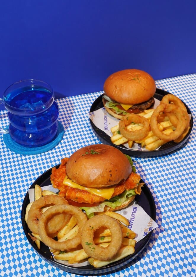 A classic beef burger and a hot chicken burger with fries and onion rings