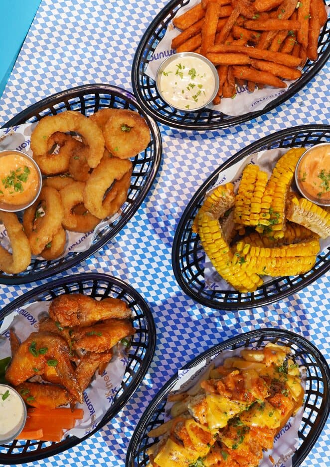 Baskets of onion rings, corn ribs, sweet potato fries and buffalo wings